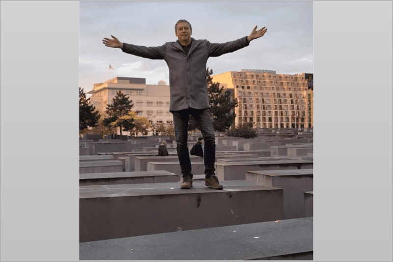 Alternative for Germany representative Holger Winterstein posing with outstretched arms on one of the stone slabs that form the Holocaust Memorial in Berlin. (Twitter, used in accordance with Clause 27a of the Copyright Law)